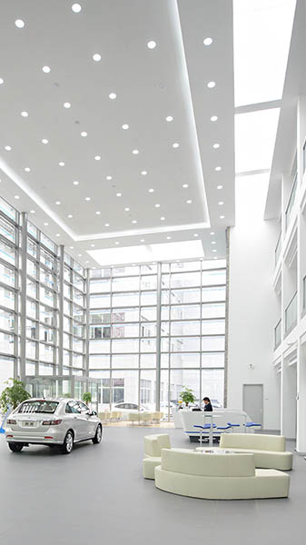 Schöne, hohe, helle Halle, in der ein Auto und ein Sofa stehen.