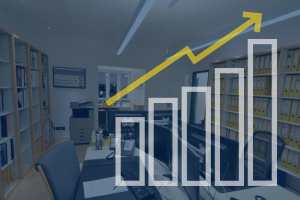 Im Hintergrund ist ein Büro zu sehen, das von einer Diagrammgrafik überlagert wird.